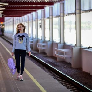 一位女性编辑在地铁车厢里低头查看手机上的换乘信息，车厢内灯光偏冷，画面生活化